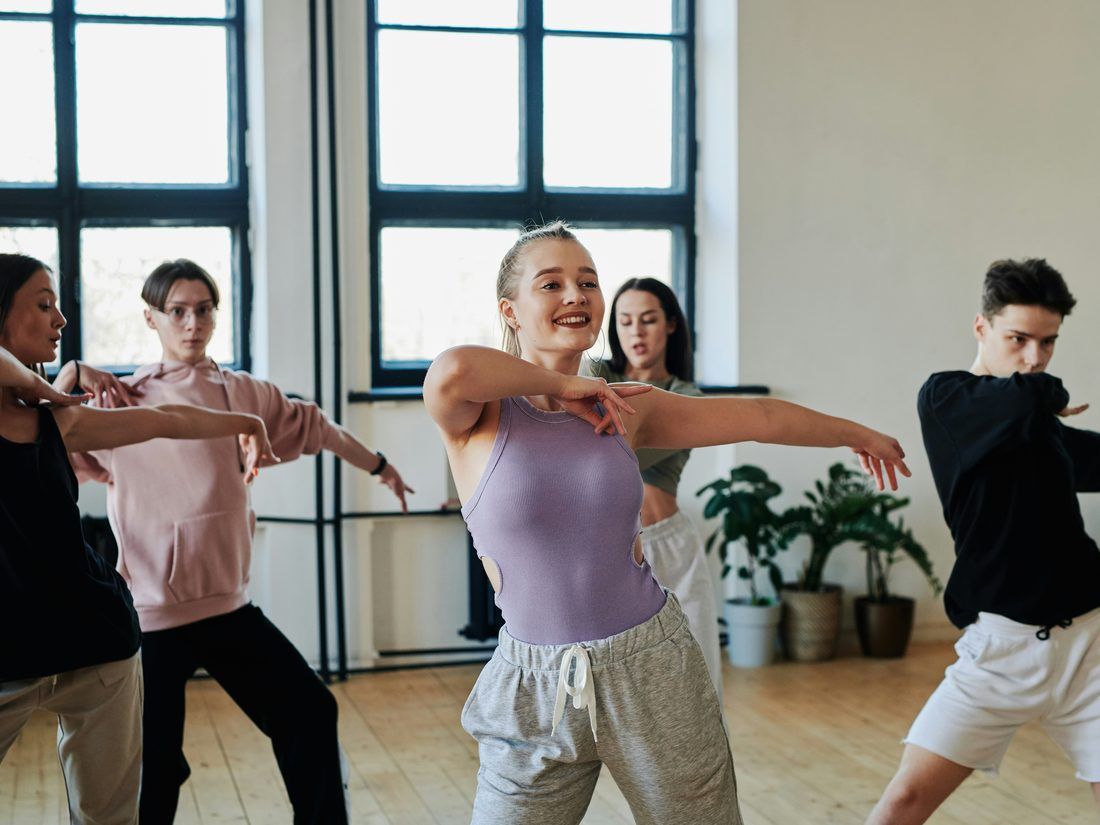Una clase de baile captada en pleno giro en una sala con espejos