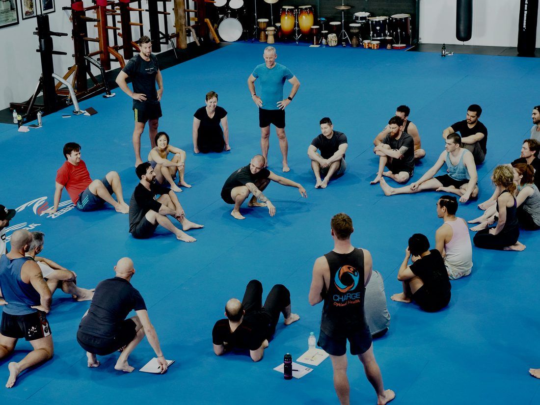 Trabajo con manoplas en el tatami, entrenador y alumno en plena combinación
